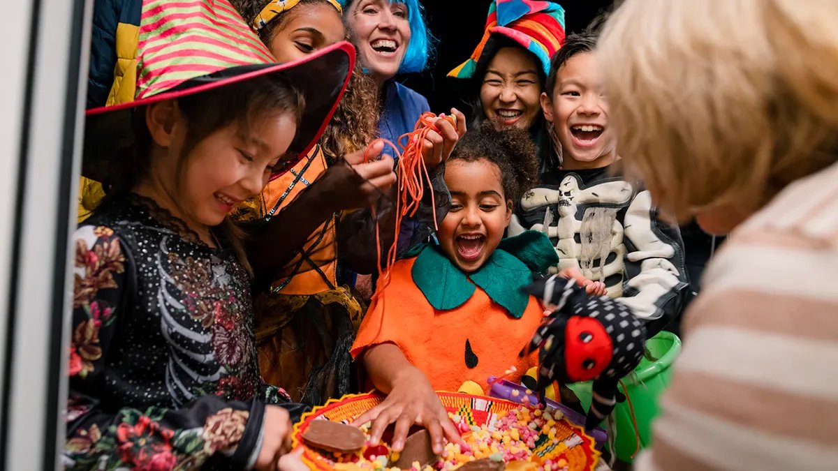 A happy child holding a healthier candy alternative, such as a colorful organic lollipop.