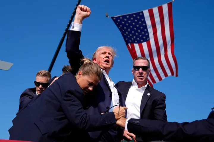 Donald Trump surrounded by Secret Service agents after the assassination attempt in Butler, Pennsylvania.