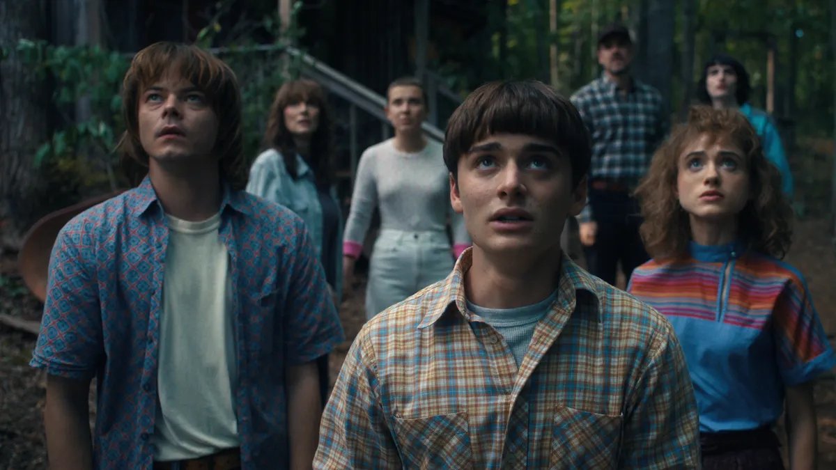 The main cast of Stranger Things looking concerned, possibly confronting a threat from the Upside Down.