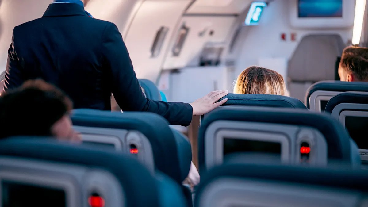 Flight attendant demonstrating safety procedures