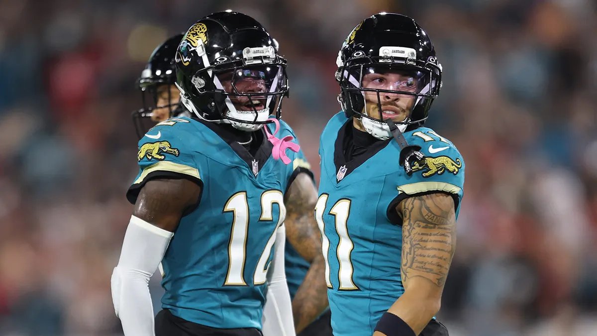 Jaguars quarterback and offensive coordinator discussing strategy on the sidelines after Travis Hunter's injury.