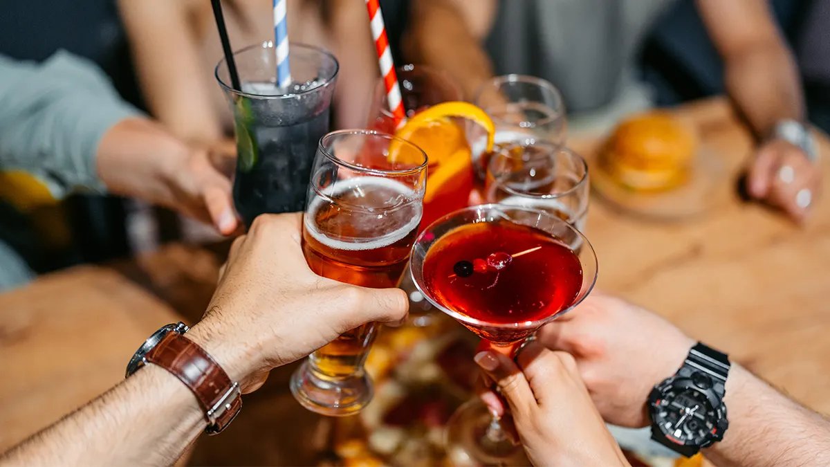 A traveler carefully examining a bottle of alcohol before purchase