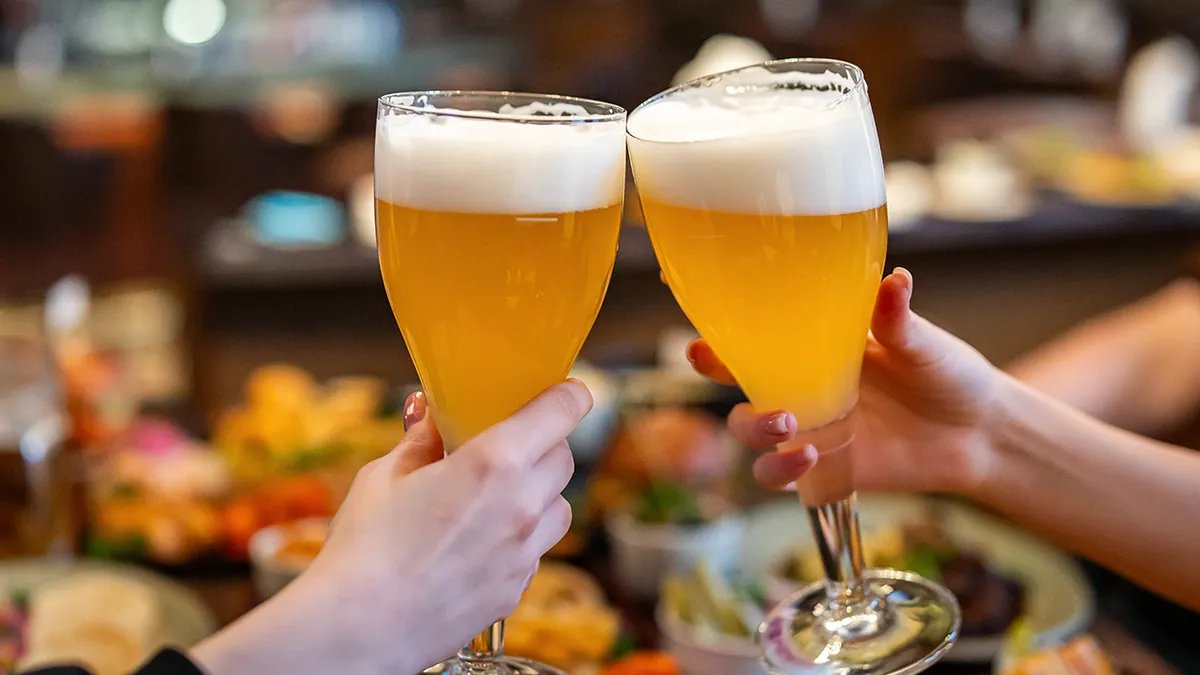 A relaxed evening scene at a brewery taproom featuring adults enjoying beverages.