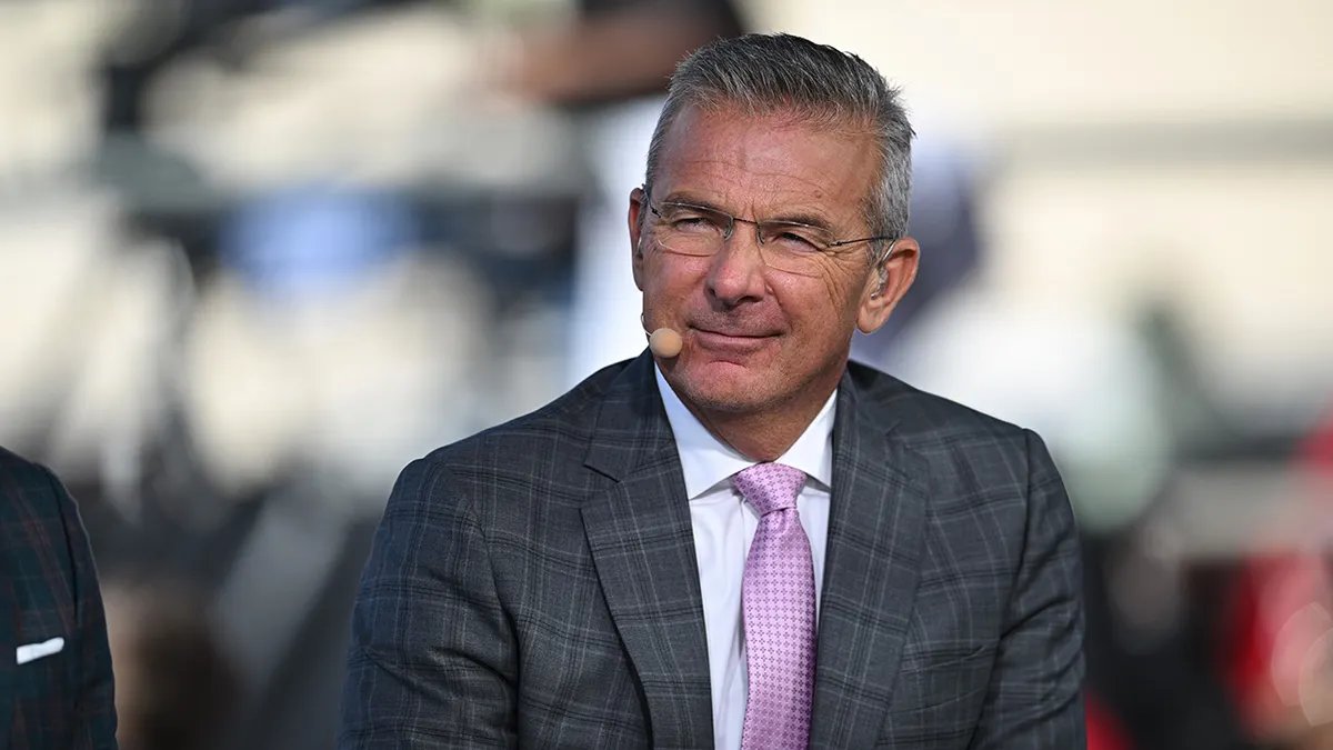 High-Profile College Football Jobs Remain Open Despite Urban Meyer Ruling Out Comeback A high-profile college stadium during a nighttime game, symbolizing the intense pressure of the job.