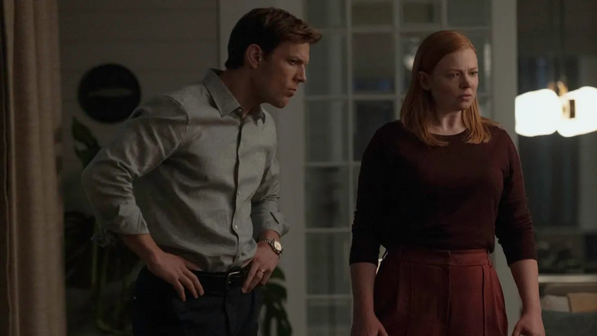 A woman looking stressed while juggling multiple responsibilities, symbolizing modern motherhood's burdens.