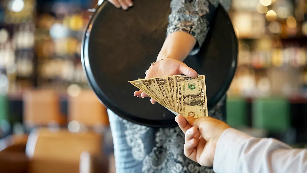 A waiter taking an order, illustrating the human element of service in restaurants.