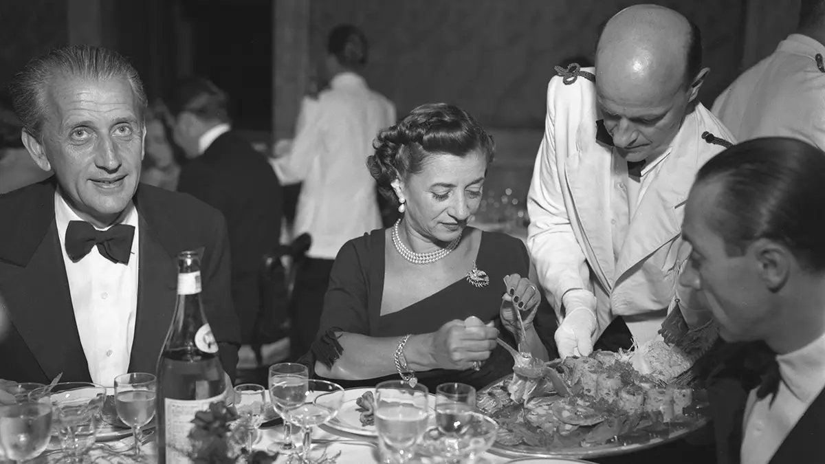 A close-up of a chef clarifying a broth for a sophisticated savory gelatin dish.