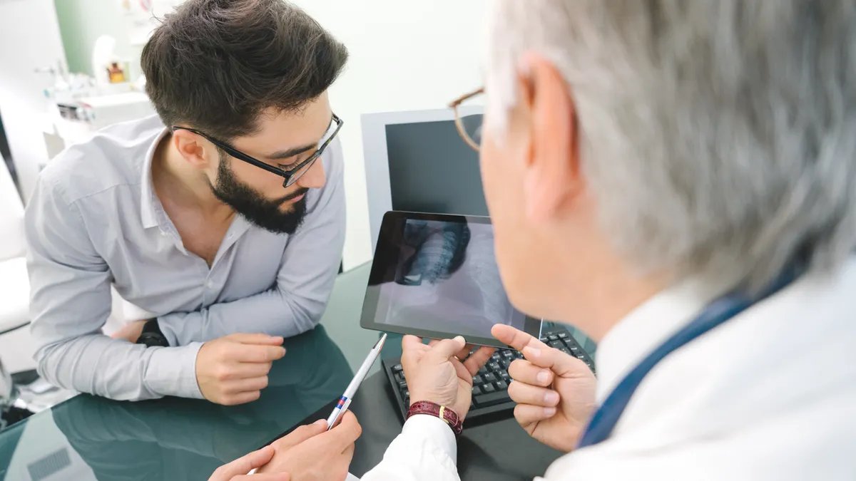 A diverse group of parents, educators, and community members engaged in a discussion or workshop about youth health and media literacy, perhaps looking at educational materials or debating solutions.