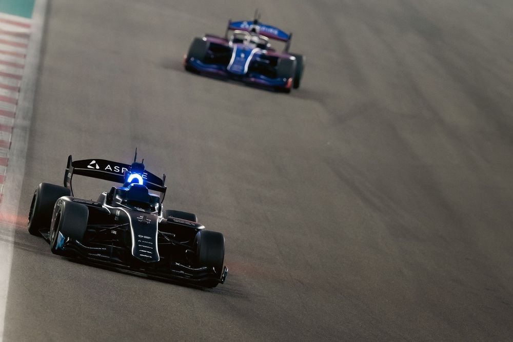 An A2RL autonomous car speeding through a high-speed corner, with blurred background indicating motion.