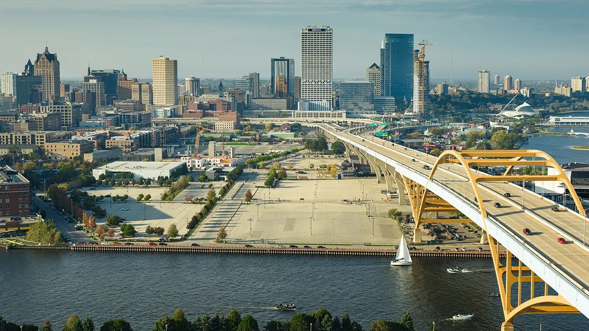 A sizzling cheeseburger being cooked on a flat-top grill, showing the cooking process.