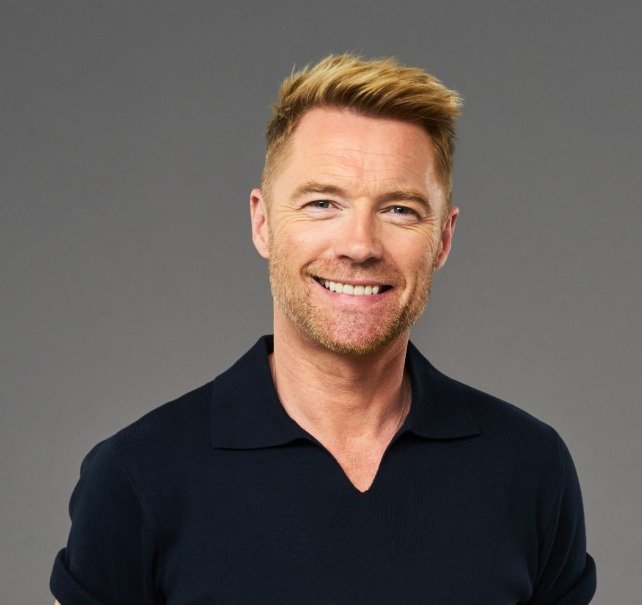 Timbaland performing on stage, mic in hand, engaging with audience.