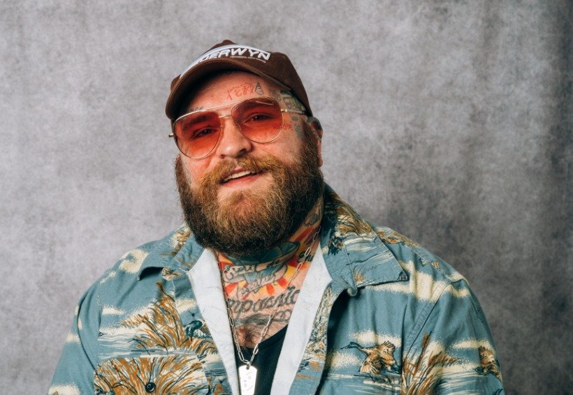 DJ spinning records in a dimly lit club, crowd dancing.