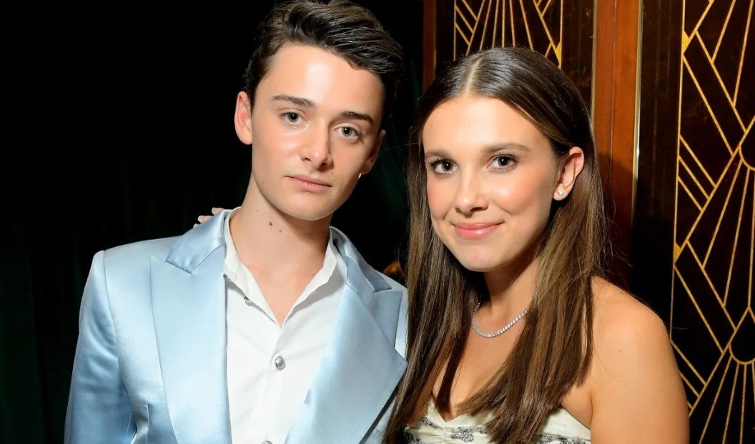 Finn Wolfhard playing guitar on stage.