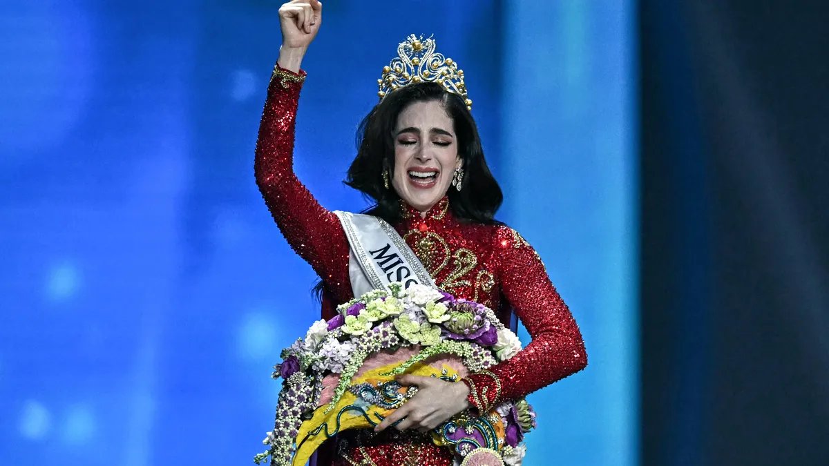 A radiant Miss Mexico 2025, Sofia Ramirez, holding the Miss Universe crown with immense joy and national flag in the background, a symbol of her country's pride.