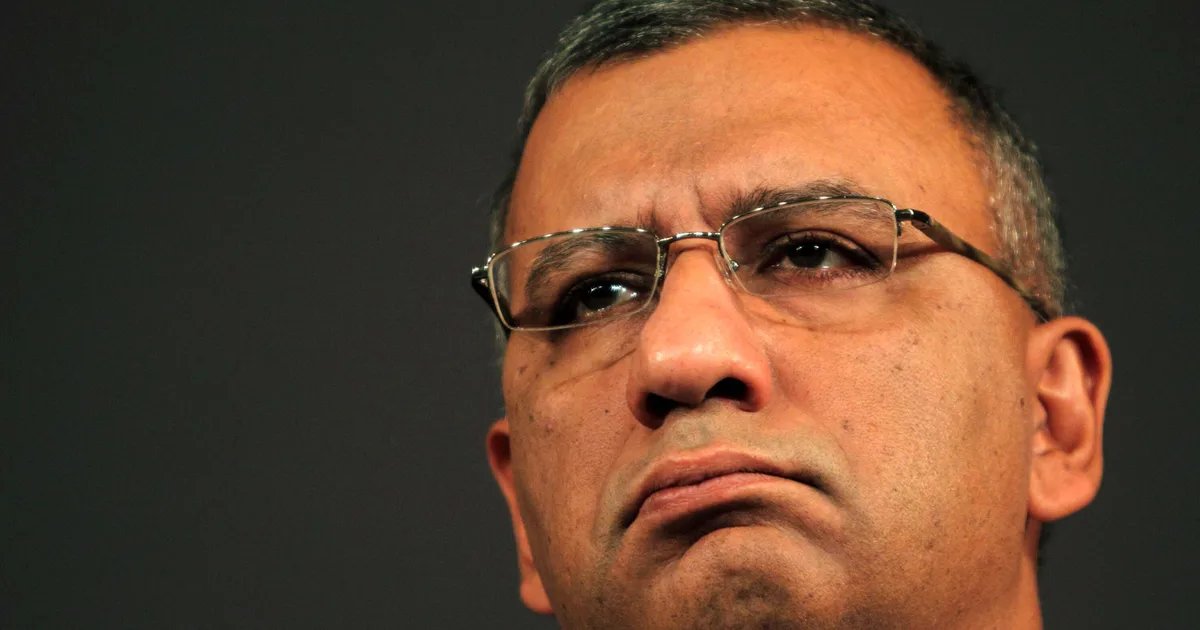 A somber, blurred image of the BBC Broadcasting House in London, with grey skies overhead, symbolizing the recent controversy and resignation.