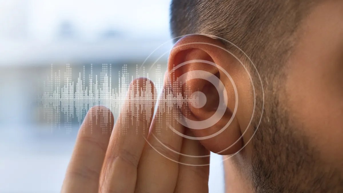 A futuristic graphic interface showing sound waves and medical data, symbolizing advanced auditory research and treatment options.