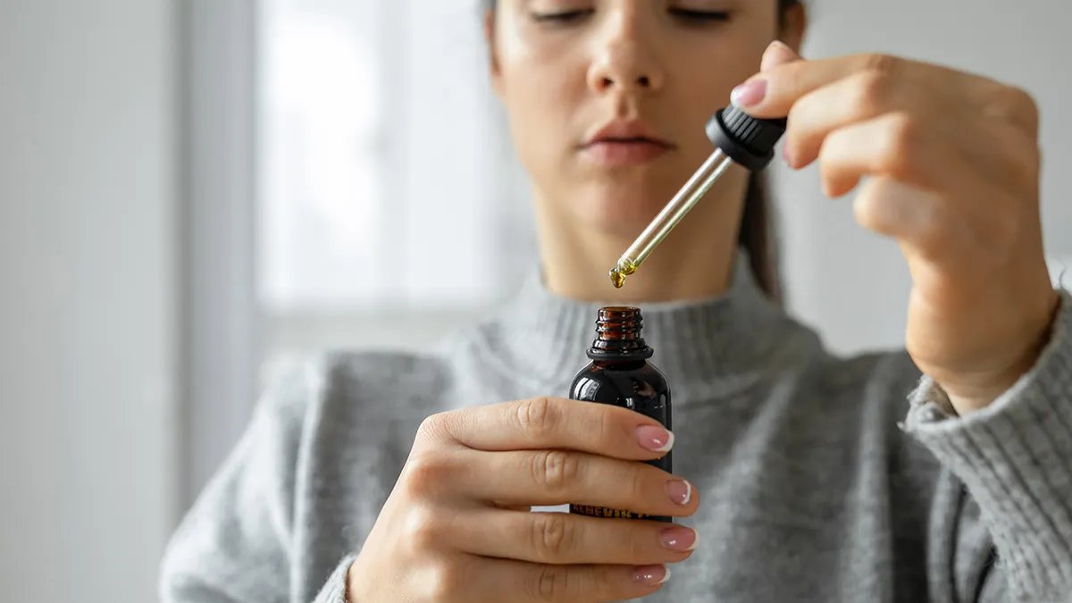 A doctor or researcher holding a test tube with a yellow liquid, representing scientific research.