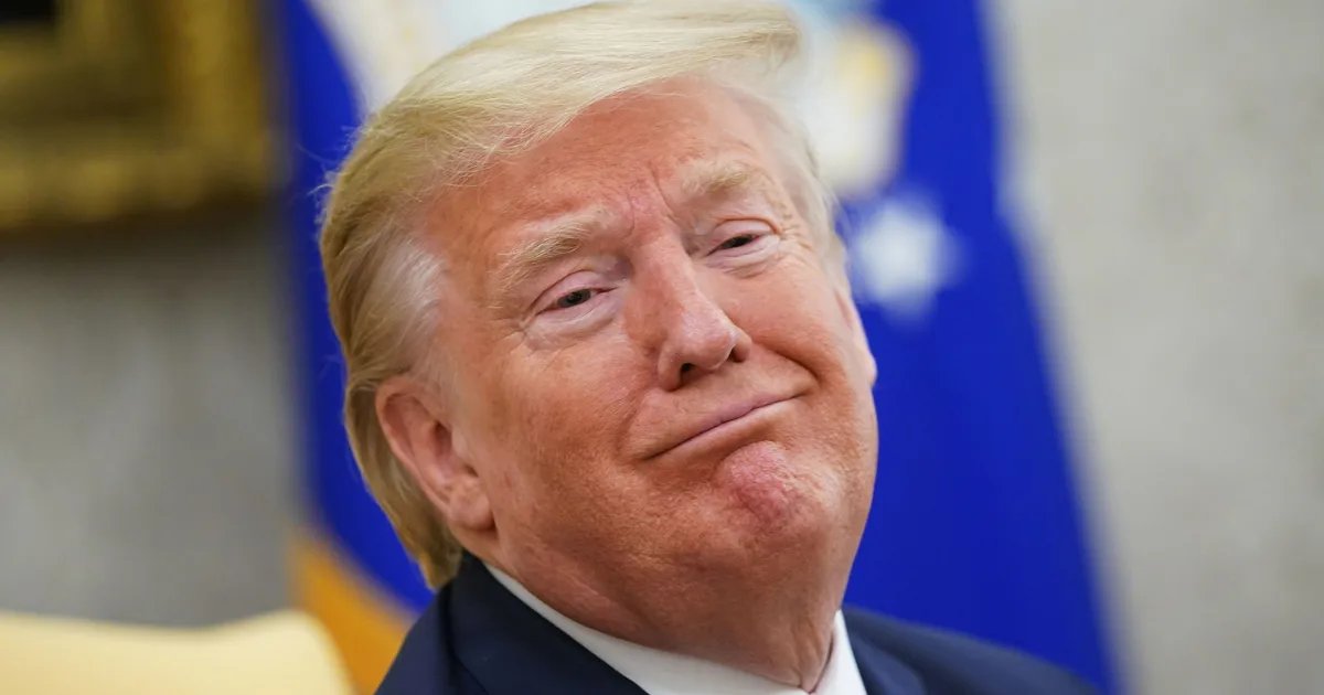 Donald Trump addressing a crowd, with supporters holding MAGA signs.