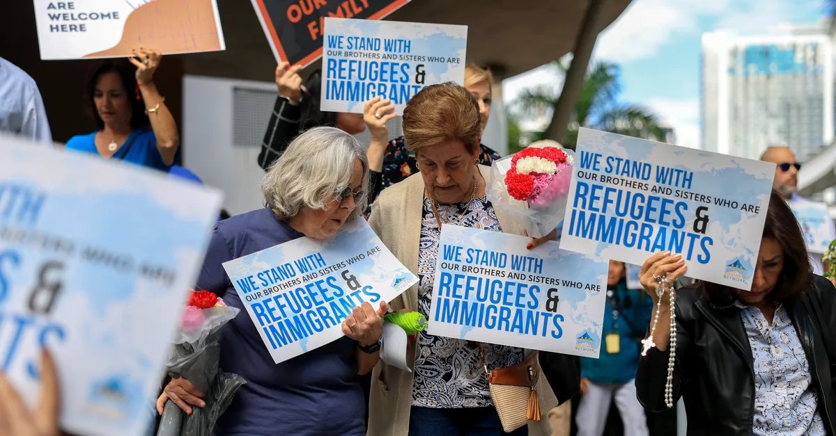 A group of refugees arriving at an airport, carrying their belongings.