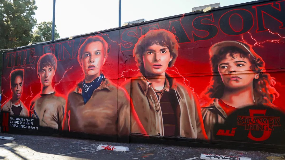 The Stranger Things cast poses in front of a fiery backdrop, hinting at the epic battles to come in Season 5.