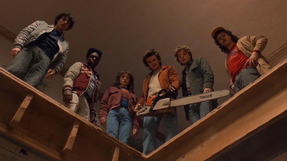 Stranger Things cast standing together, looking determined.
