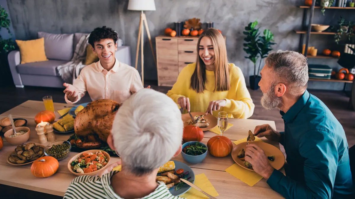 A happy family gathered around a Thanksgiving table.
