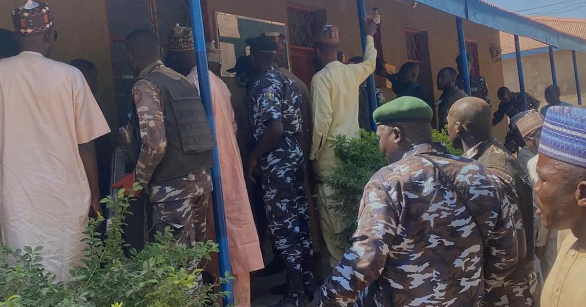 A group of concerned parents gathered outside a government building, holding placards with photos of their missing daughters, demanding answers and action from the authorities in Nigeria.