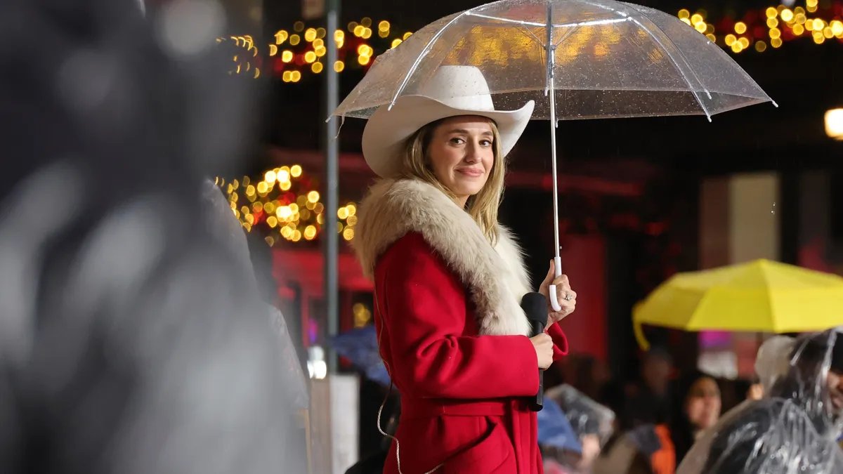 Lainey Wilson smiles warmly at the camera, showcasing her signature bell-bottom style.