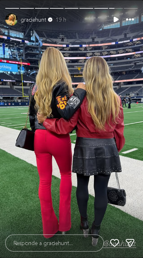 A candid shot of Gracie Hunt and one of the Cavinder twins laughing together during the game.