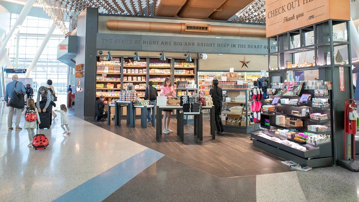 A woman choosing a healthy snack at an airport kiosk.