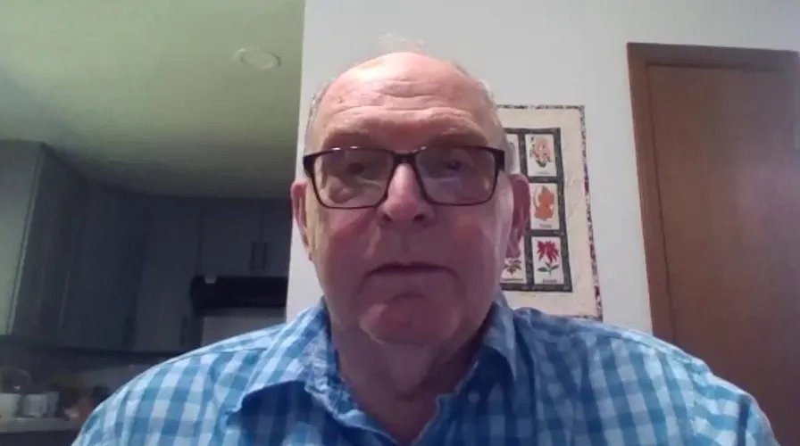 A scientist in a lab coat looks intently through a microscope, surrounded by advanced research equipment.