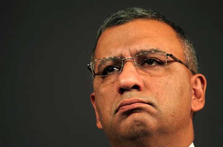 A close-up of a hand holding a magnifying glass over a newspaper headline about media impartiality, symbolizing scrutiny and investigation.