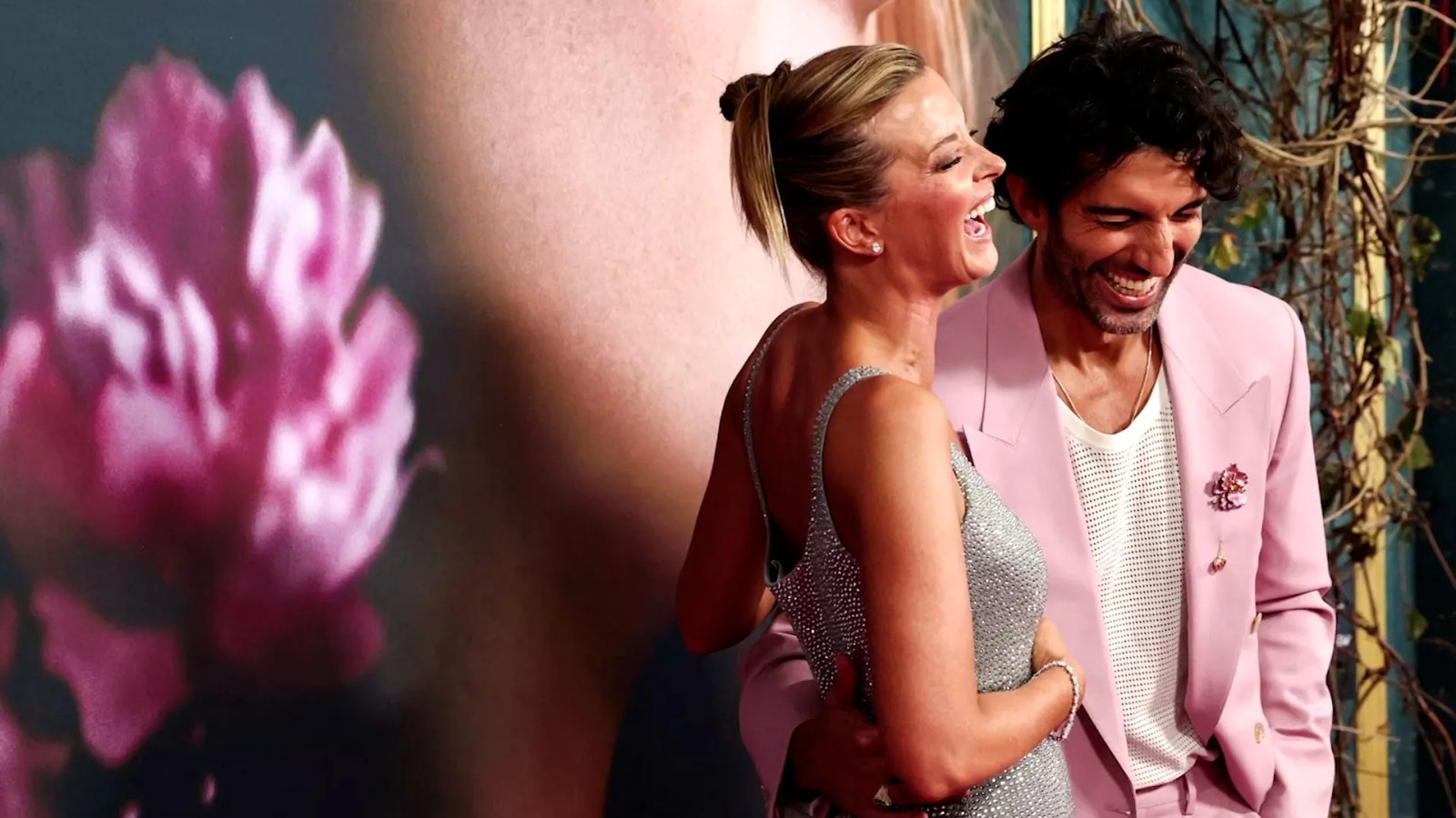 Justin Baldoni giving a speech on stage, a serious expression on his face.