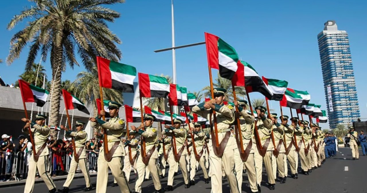 A solemn ceremony taking place on Commemoration Day in the UAE, with military personnel standing in formation and paying their respects.