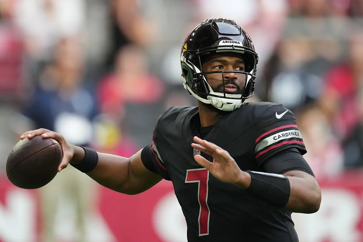 Jacoby Brissett looking dejected after a tough game, with fans in the background expressing frustration.