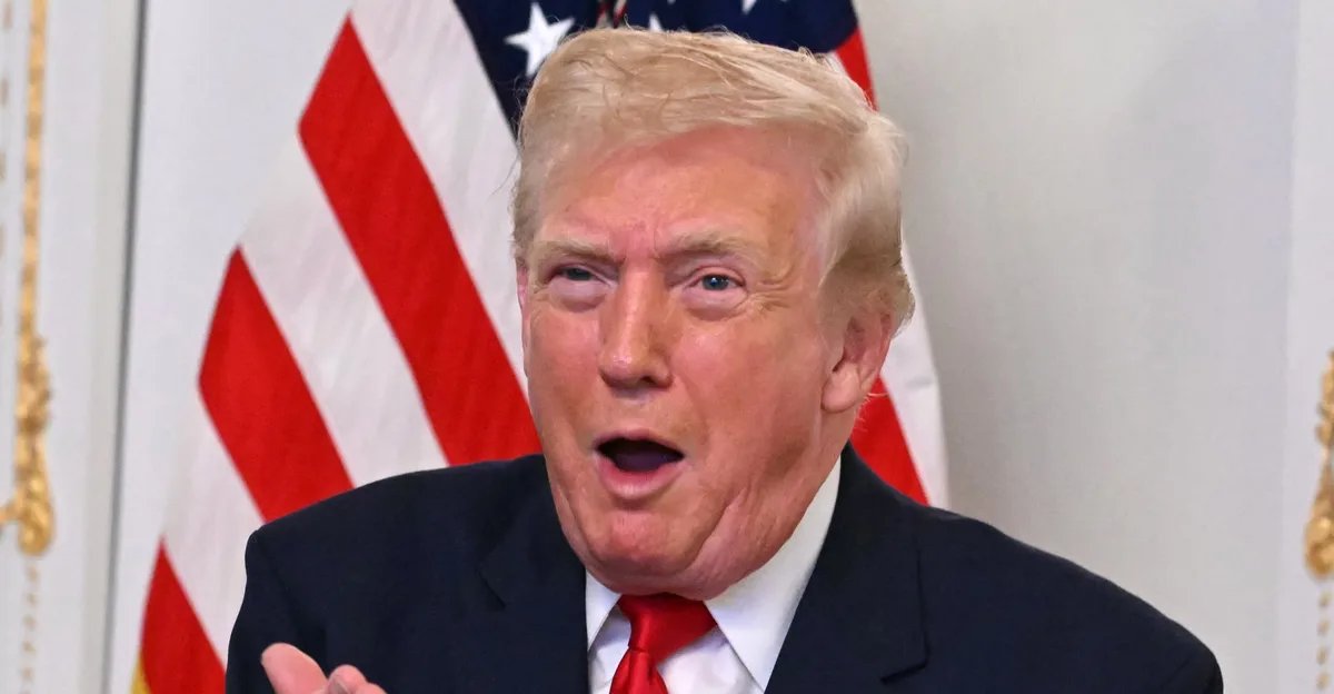 Indiana Statehouse with American and Indiana flags waving in front of a clear blue sky.