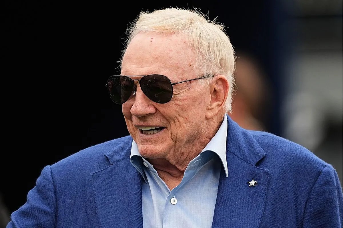 Jerry Jones standing on the sideline, watching his team compete with an intense expression.