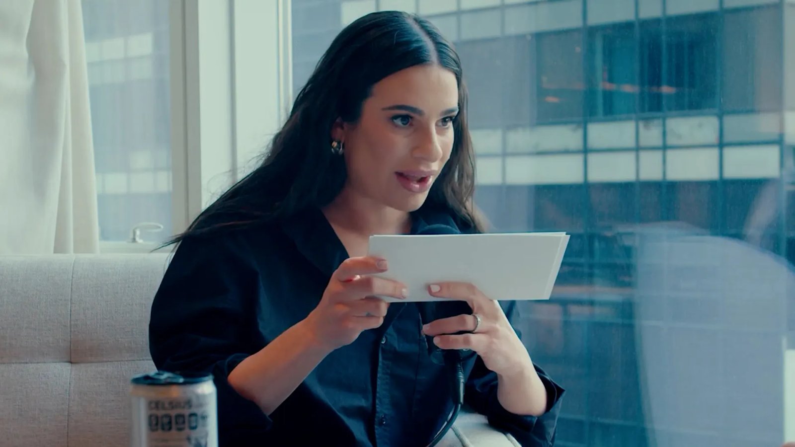 Lea Michele, bathed in dramatic lighting, sings passionately on stage during a 'Chess' performance.