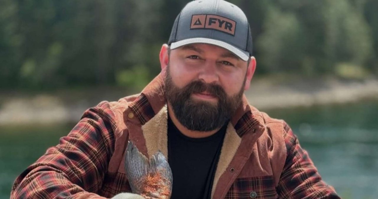 Michael Duarte smiling and holding a plate of food.