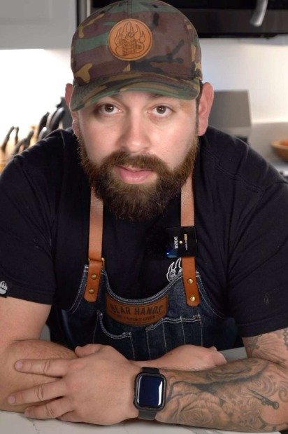 A black and white photo of Michael Duarte, looking thoughtful, with a subtle culinary background.
