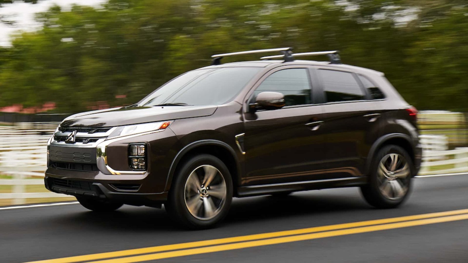 A Mitsubishi Mirage driving down a city street, showcasing its compact size and practical design.