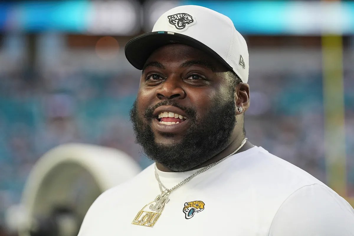 Chad Henne standing on the sideline in his Jaguars uniform, looking thoughtful.
