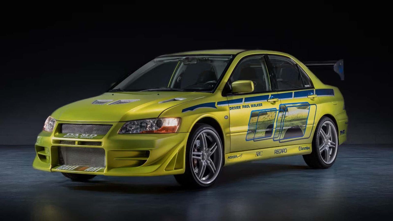 Paul Walker's iconic green Mitsubishi Lancer Evolution from 2 Fast 2 Furious, parked and ready for auction, evoking memories of the legendary actor.