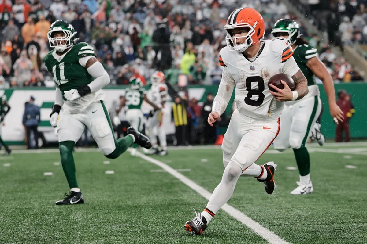 Shedeur Sanders poised in the pocket, eyeing a receiver downfield during a game.