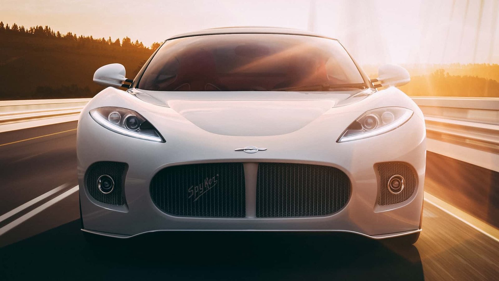 A silver Spyker C8 Laviolette parked on a cobblestone street.
