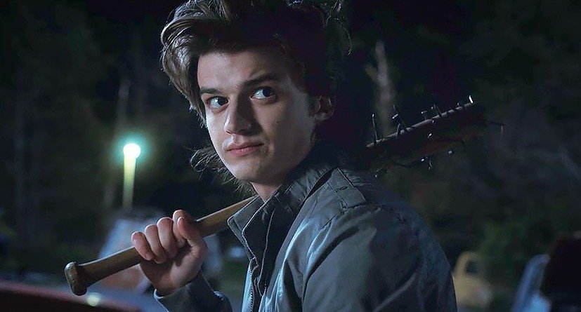 Joe Keery as Steve Harrington, looking concerned with a flashlight in hand, in Stranger Things.