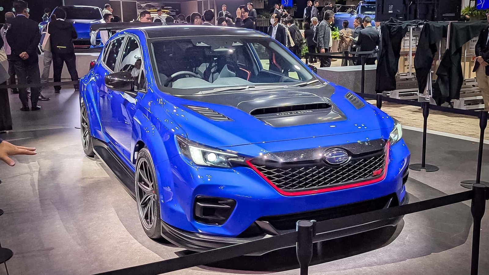 A striking front three-quarter view of the new Subaru STI concept car, showcasing its aggressive styling and distinctive headlights.