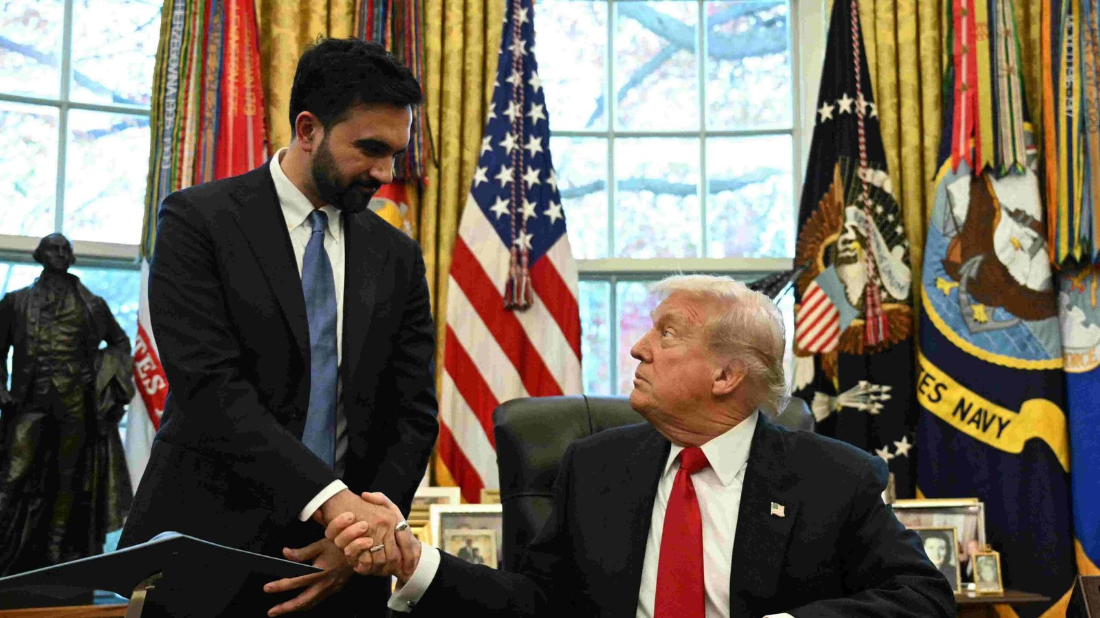 Donald Trump and Zohran Mamdani seated at a table, engaged in discussion.