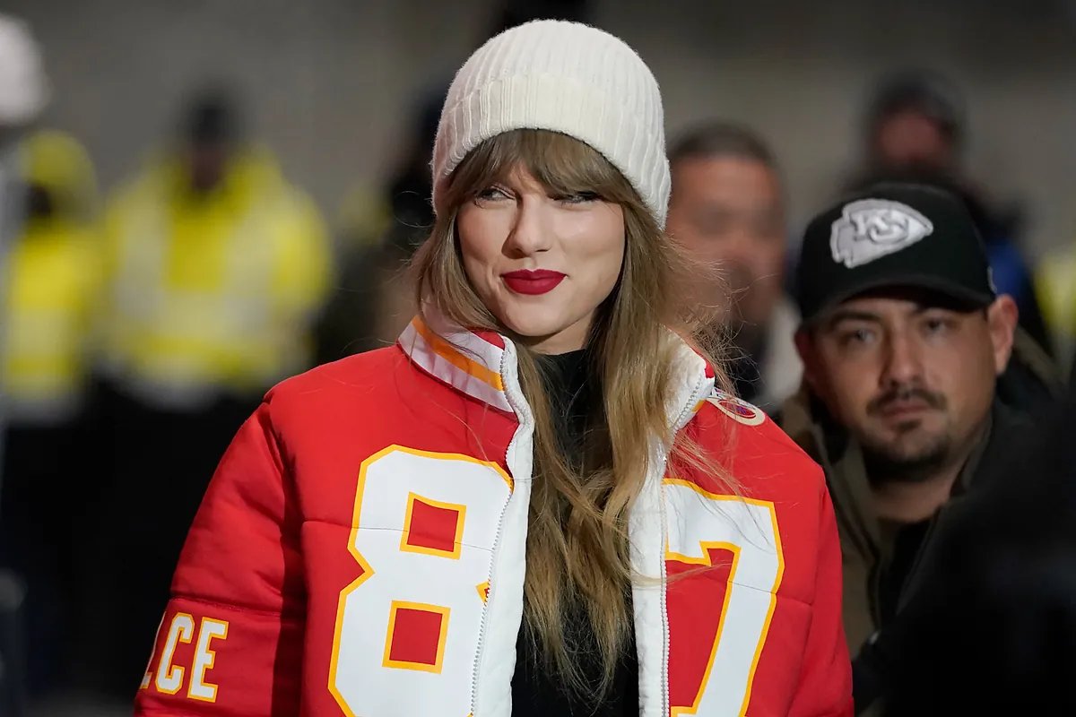 Taylor Swift shielding her face from camera flashes, indicating she is tired of being hounded by the cameras