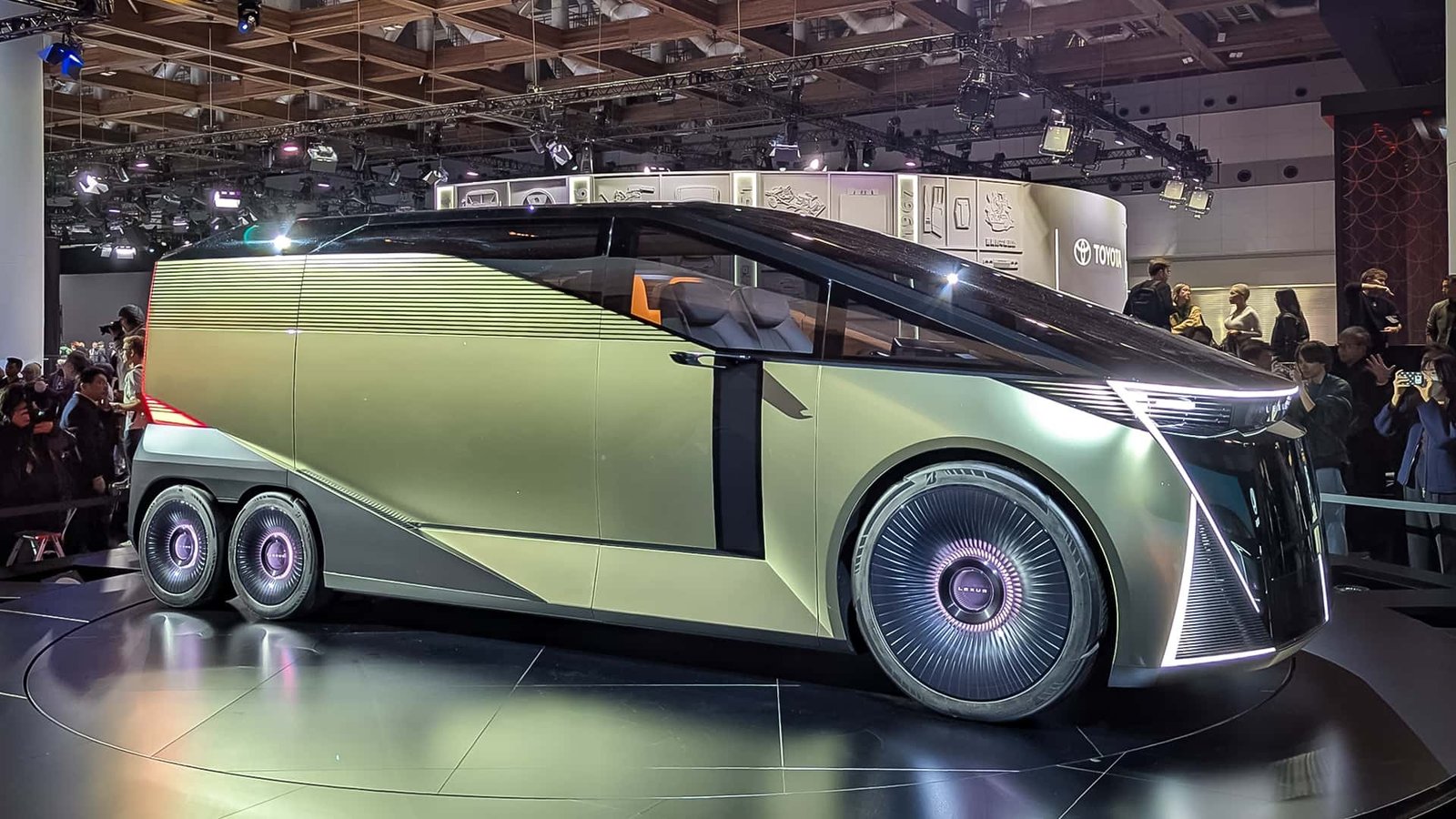 The Lexus LS Concept six-wheel luxury minivan on display, showcasing its elongated profile and unique wheel arrangement.